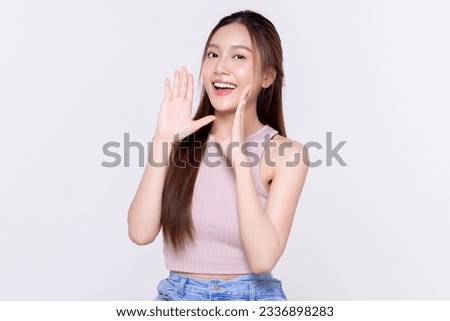 Beautiful young Asian woman with open mouths raising hands screaming announcement on isolated white background. Facial and skin care concept for commercial advertising.