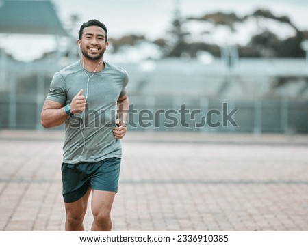 Sports, portrait and male athlete running with earphones for music, radio or podcast for motivation. Fitness, exercise and man runner in outdoor cardio workout routine for race or marathon training. Royalty-Free Stock Photo #2336910385