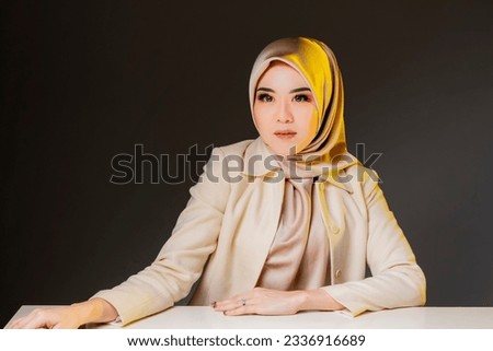 Beautiful corporate women in hijab over studio background.