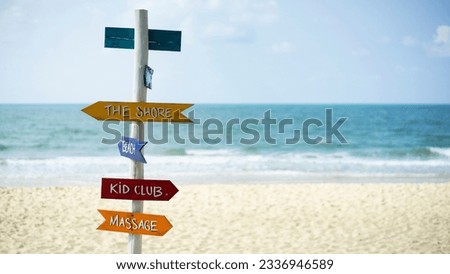 Signs pointing on a tropical beach against the background of the sea and white sand beach. Beautiful white sand beach and signs in Thailand. 