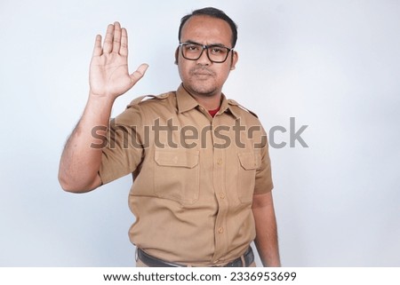 a man Asian civil servants or state civil servants is with brown uniform. gesture pose rejection or prohibition . On white background. Indonesia PNS, ASN