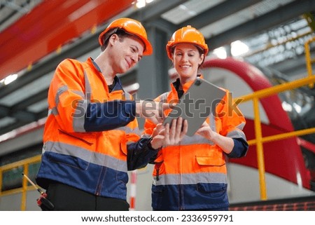 Engineers inspecting locomotive in railway engineering facility Royalty-Free Stock Photo #2336959791