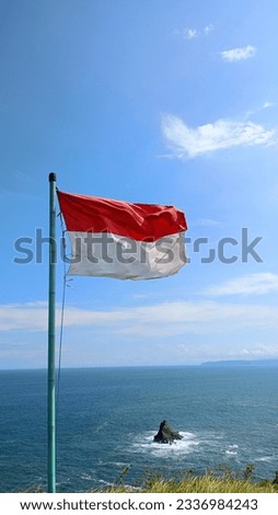 the Indonesian flag fluttering on the beach in the wind looks very beautiful, the blue sky and beaches make the scenery very pleasing to the eye