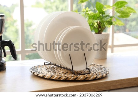 Wicker mat with plate rack on wooden countertop, closeup Royalty-Free Stock Photo #2337006269