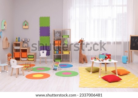 Child`s playroom with different toys and furniture. Cozy kindergarten interior Royalty-Free Stock Photo #2337006481