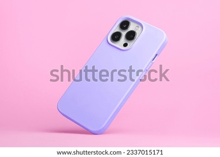smart phone in purple soft silicone case falls down back view, iPhone 15 Pro Max case mockup isolated on pink background
