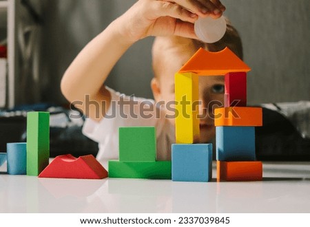 game colored geometric shapes children close-up on the table and the child plays selective focus Royalty-Free Stock Photo #2337039845
