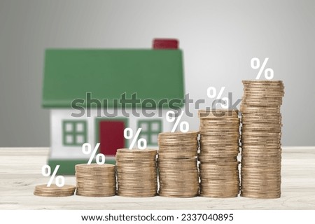 the percentage symbol on coins stacks and house on background