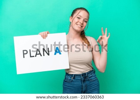 Young caucasian woman isolated on green background holding a placard with the message PLAN A with ok sign
