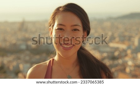 Close-up of young smiling woman looking at the camera while standing on viewing platform