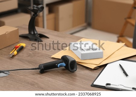 Black modern barcode scanner on wooden table in office. Online store Royalty-Free Stock Photo #2337068925