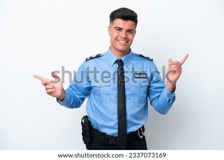 Young police caucasian man isolated on white background pointing finger to the laterals and happy