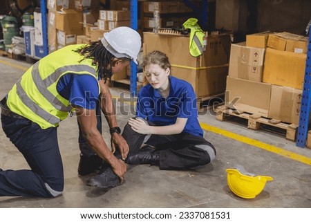 young woman warehouse worker accident leg injury slip and fall ankle sprain friend help support Royalty-Free Stock Photo #2337081531