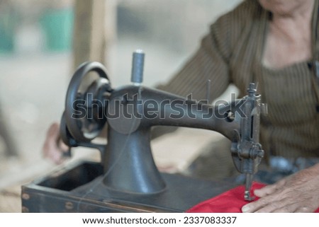 Close up picture with blur background an Old stitching and sewing machine running by hand