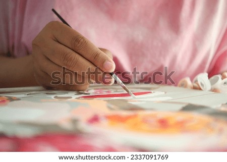 women hand holding brush with paint 