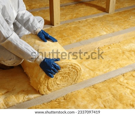 Worker insulate the attic with mineral wool Royalty-Free Stock Photo #2337097419