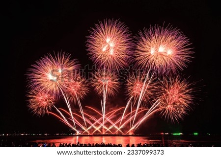 PATTAYA, CHONBURI, THAILAND Beautiful colorful fireworks night scene at Pattaya International Fireworks Festival and silhouette Group of tourist take pictures of firework show on the beach,
