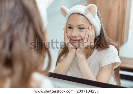Teen girl washing face in morning in bathroom. Self Care morning bathroom routine child portrait reflection in mirror