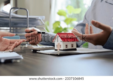 Real Estate Agent and client talking about Property insurance and security concept about house to client before sign contract.