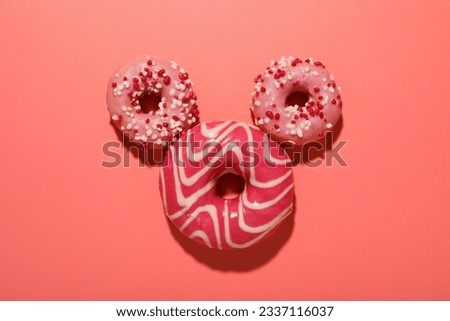 Pink glazed donuts on pink background, top view
