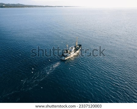 Aerial view of fishing boat surrounded by black-headed gulls in coming back to the port in Black Sea. Horizontal picture