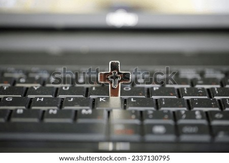 Keyboard of a computer with a cross on it. Conceptual photography