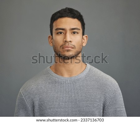 Serious man, casual style and portrait with modern fashion in a studio. Male model, grey background and young person from Philippines of a handsome Asian adult with confidence, attitude and jersey Royalty-Free Stock Photo #2337136703