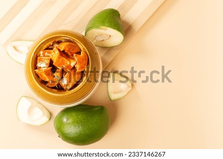 Andhra traditional home made raw mango sweet and spicy  pickle in a traditional pickle jar placed on a clean light brown  background- Selective focus
 Royalty-Free Stock Photo #2337146267