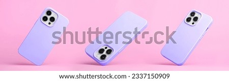 set of three iPhone 15 and 14 Pro max in purple silicone case falling down in different angles, back view isolated on pink background, phone case mockup