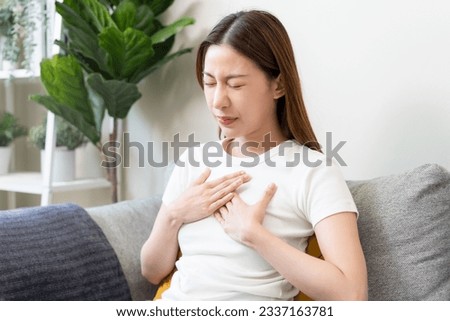 Acid reflux disease, suffer asian young woman have symptom gastroesophageal, esophageal, stomach ache and heartburn pain hand on chest from digestion problem after eat food, Healthcare medical concept Royalty-Free Stock Photo #2337163781