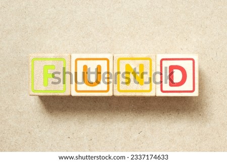 Wooden alphabet letter block in word fund on wood background