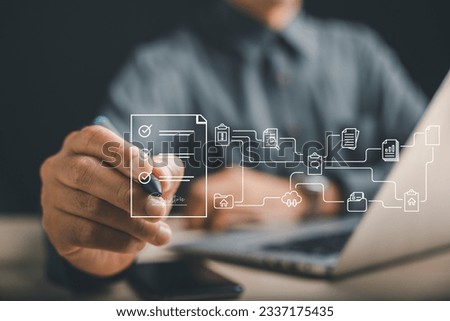 Businessman's hand uses stylus to sign digital document on laptop screen. E-signing, digital document management, and paperless office concept are highlighted. Agreement is confirmed.