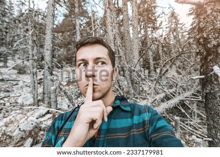 A frightened and lost male hiker heard some rustling in the forest and took it for a wild animal or a bear looks around in the forest. Royalty-Free Stock Photo #2337179981