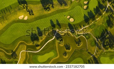 An aerial view of a golf course covered in greenery in the daylight in Oberwaltersdorf, Austria