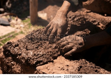 Man building with his hands an adobe house with adobe bricks and mud. Llachon region of Lake Titicaca in Peru. Royalty-Free Stock Photo #2337185309