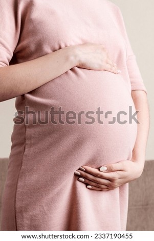 Pregnancy woman in beautiful dress standing on the home.