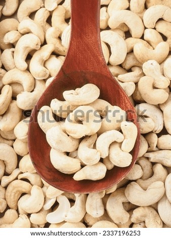 Peeled cashew nuts lie in wooden spoon. Top view of nuts close-up. Advertising photography for marketplaces or online stores.