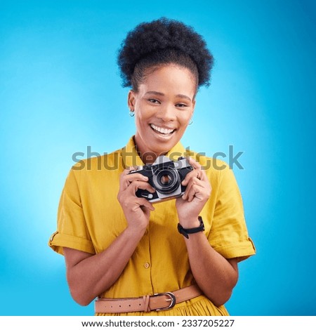 Photography, portrait and black woman with camera, smile and isolated on blue background, creative artist job and talent. Art, face of happy photographer with hobby or career in studio for photoshoot