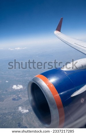 Airplane flight. Wing of an airplane flying above the clouds. View from the window of the plane. Airplane, Aircraft. Traveling by air. Aircraft's wing and land seen through the illuminator.  Royalty-Free Stock Photo #2337217285