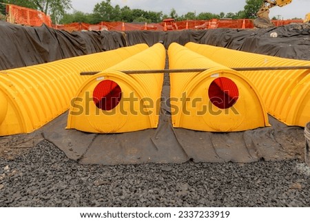 Yellow underground storm water detention mitigation units on a construction site ready to be covered.  Abstract rounded shape. Royalty-Free Stock Photo #2337233919