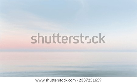 Clear blue sky sunset with glowing orange teal color horizon on calm ocean seascape background. Picturesque