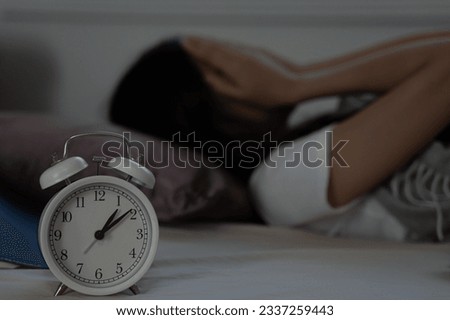 asian woman in bed late trying to sleep suffering insomnia, sleepless or scared in a nightmare, looking sad worried and stressed. Tired and headache or migraine waking up in the middle of the night. Royalty-Free Stock Photo #2337259443