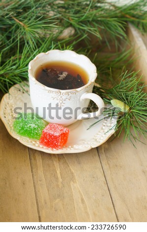 Cup of black tea with lemon and sweets on the table