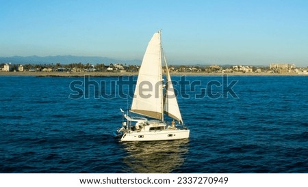 Aerial drone ultra wide photo of beautiful sailboat cruising deep blue open ocean Mediterranean sea. Sailing. Sailboat with white sails, blue sky and rippled sea background. Summer holidays. 