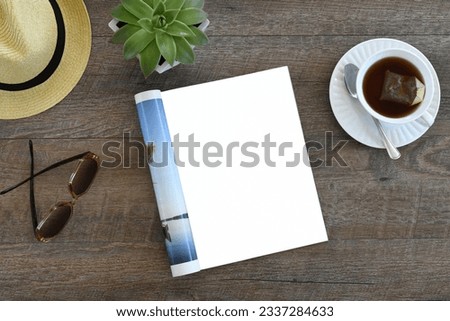 An open magazine laying on a table or desk with a white blank page for mock up. Royalty-Free Stock Photo #2337284633