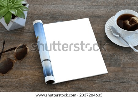 An open magazine laying on a table or desk with a white blank page for mock up. Royalty-Free Stock Photo #2337284635