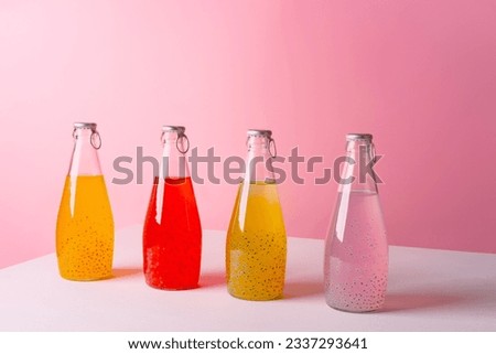 Sweet drink bottle on white table against pink background Royalty-Free Stock Photo #2337293641