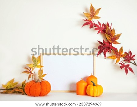 Mockup frame with pumpkins, candles and autumn leaves. Home interior with autumn fall decorations for Thanksgiving day and Halloween. Holiday poster design.