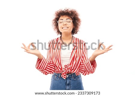 Young attractive caucasian curly woman in glasses smiling in meditative pose isolated on white studio background, making prayer gesture with fingers, keep calm and relax concept