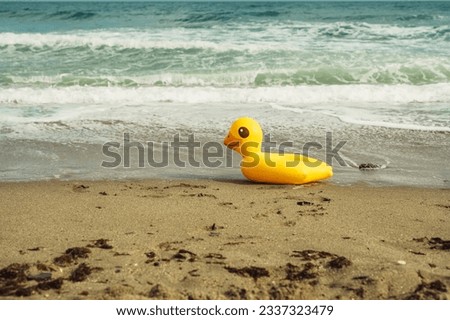 lifebuoy yellow duck on the sand on the beach on a summer day Royalty-Free Stock Photo #2337323479